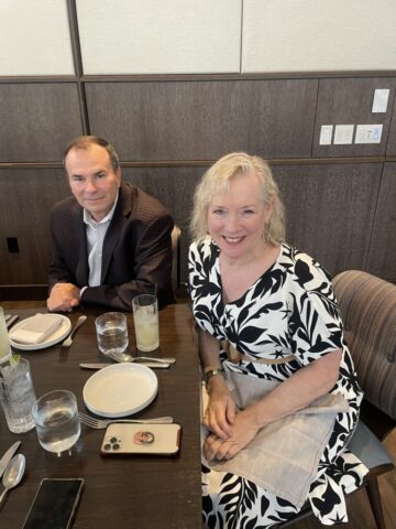 two diners smiling for a photo at their table